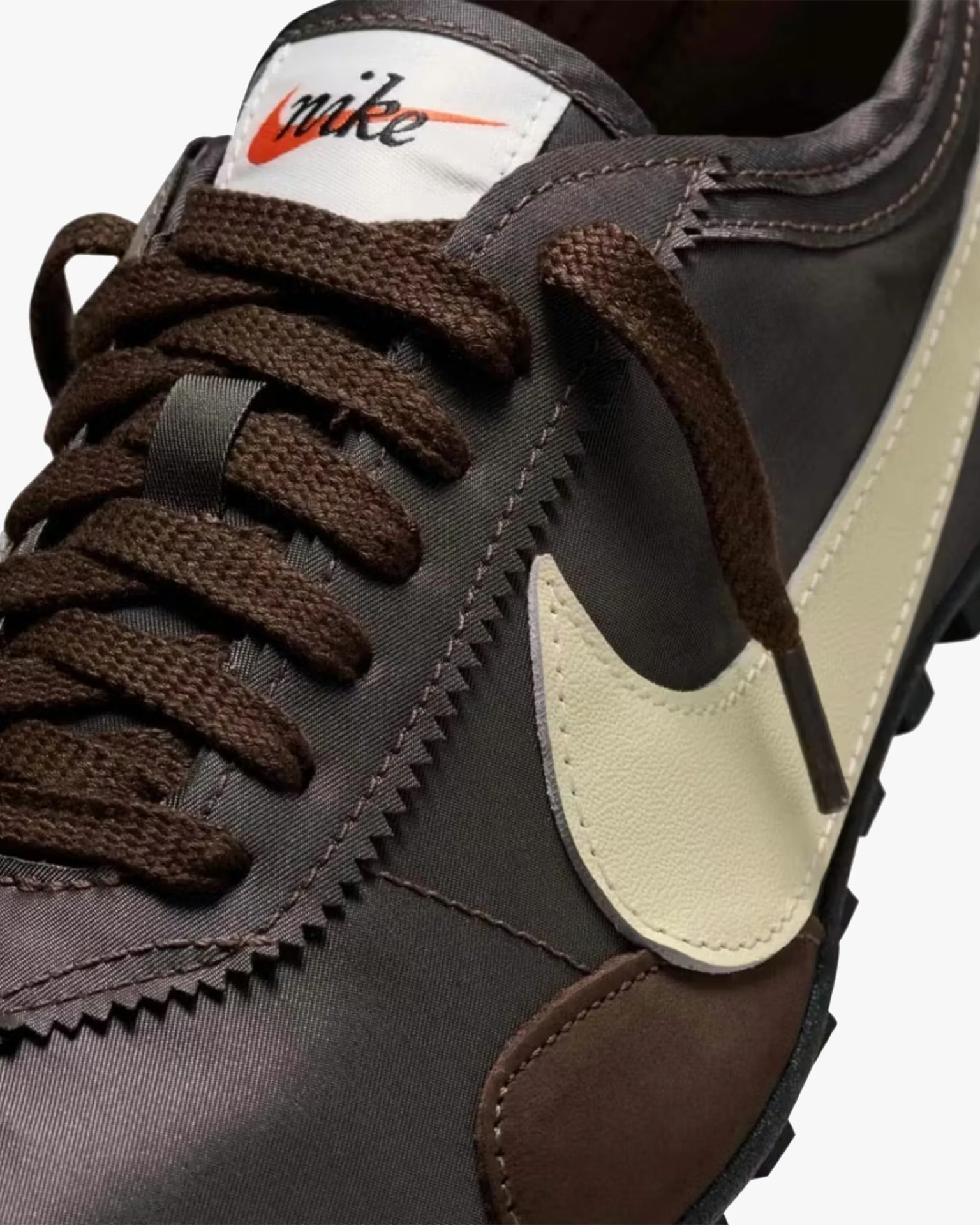 Close-up of a brown Nike sneaker with thick brown laces and a cream-colored leather swoosh.
