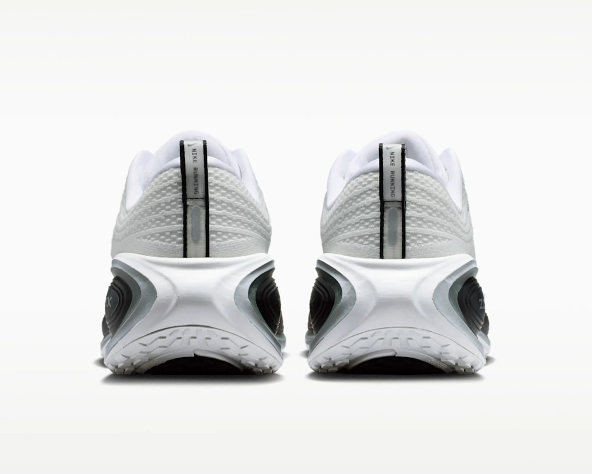 Pair of white Nike running shoes viewed from the back, showing textured fabric and black accents on the sole.
