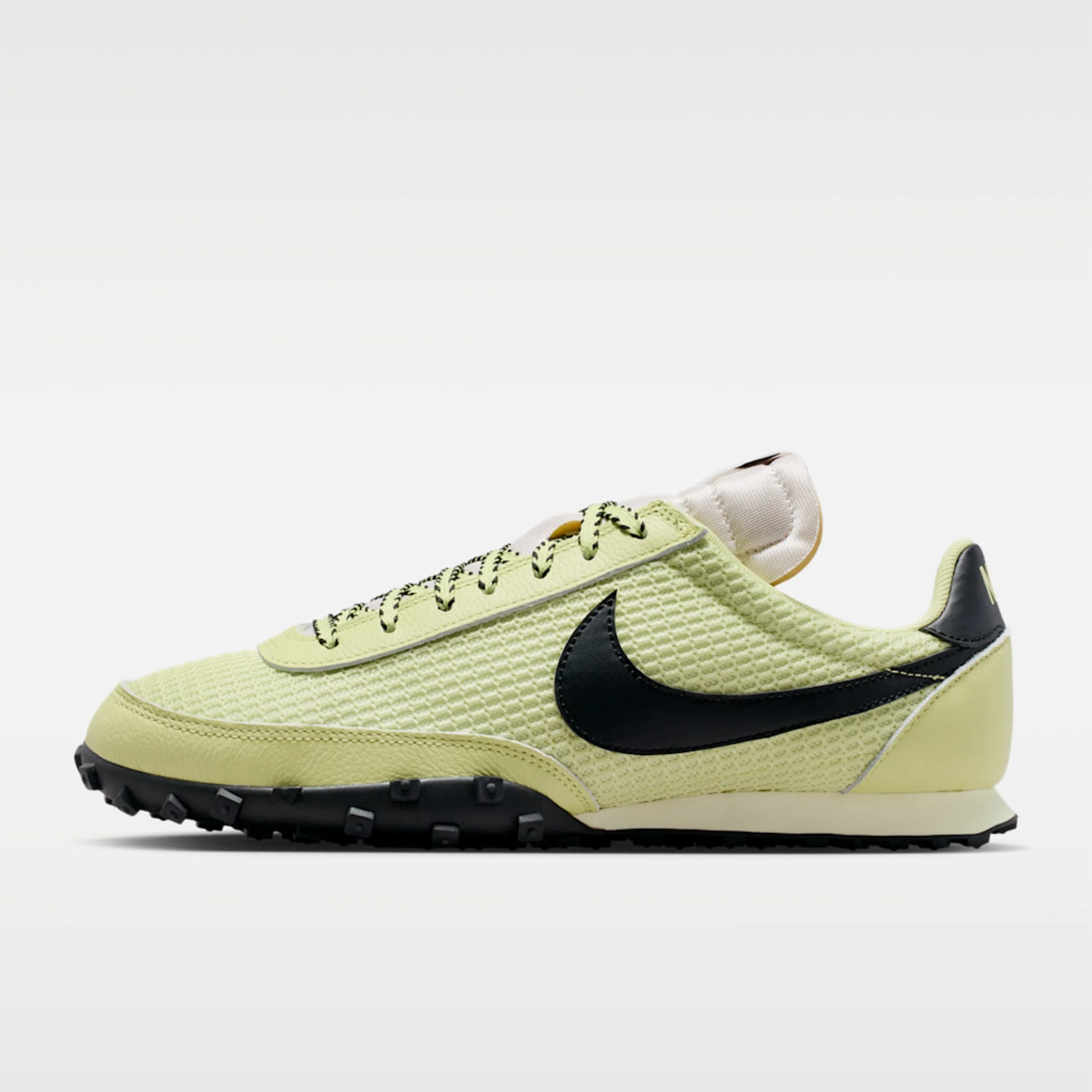 Light green textured Nike sneaker with black swoosh and black rugged sole.