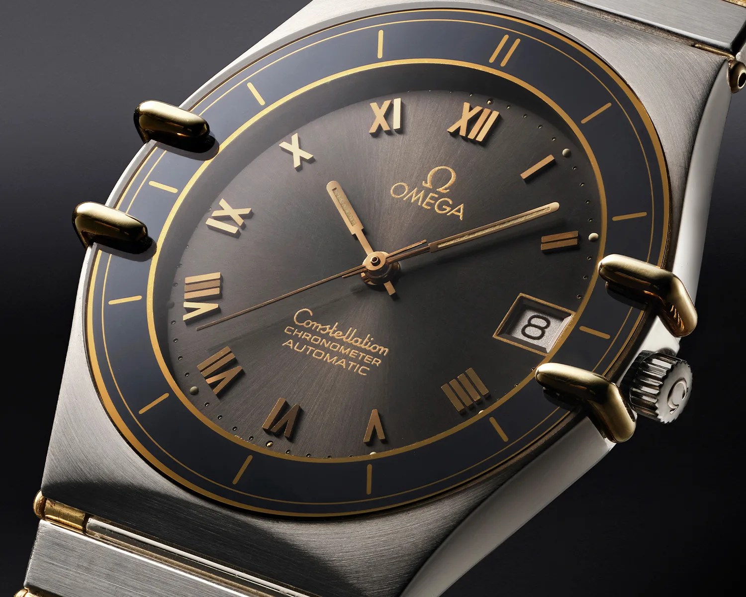 Close-up of an Omega Constellation Chronometer Automatic watch with a black and gold dial and date display at 3 o'clock.