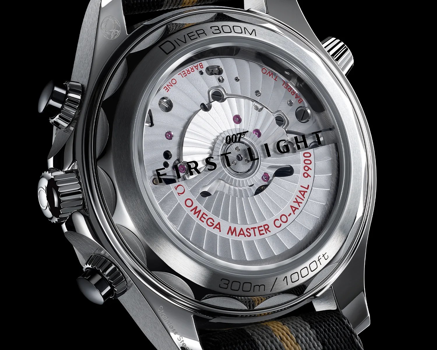 Close-up of the back of a stainless steel Omega Diver 300M watch showing the Master Co-Axial 9900 movement with "FIRST LIGHT" and "007" text on the sapphire crystal.