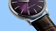 Close-up of a wristwatch with a purple dial, silver markers, and a brown leather strap against a blue background.