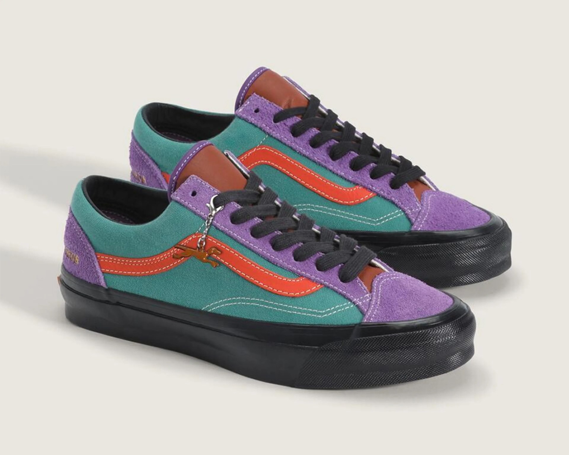 Pair of low-top sneakers with teal canvas, purple suede accents, orange side stripe, black laces, and black rubber soles.