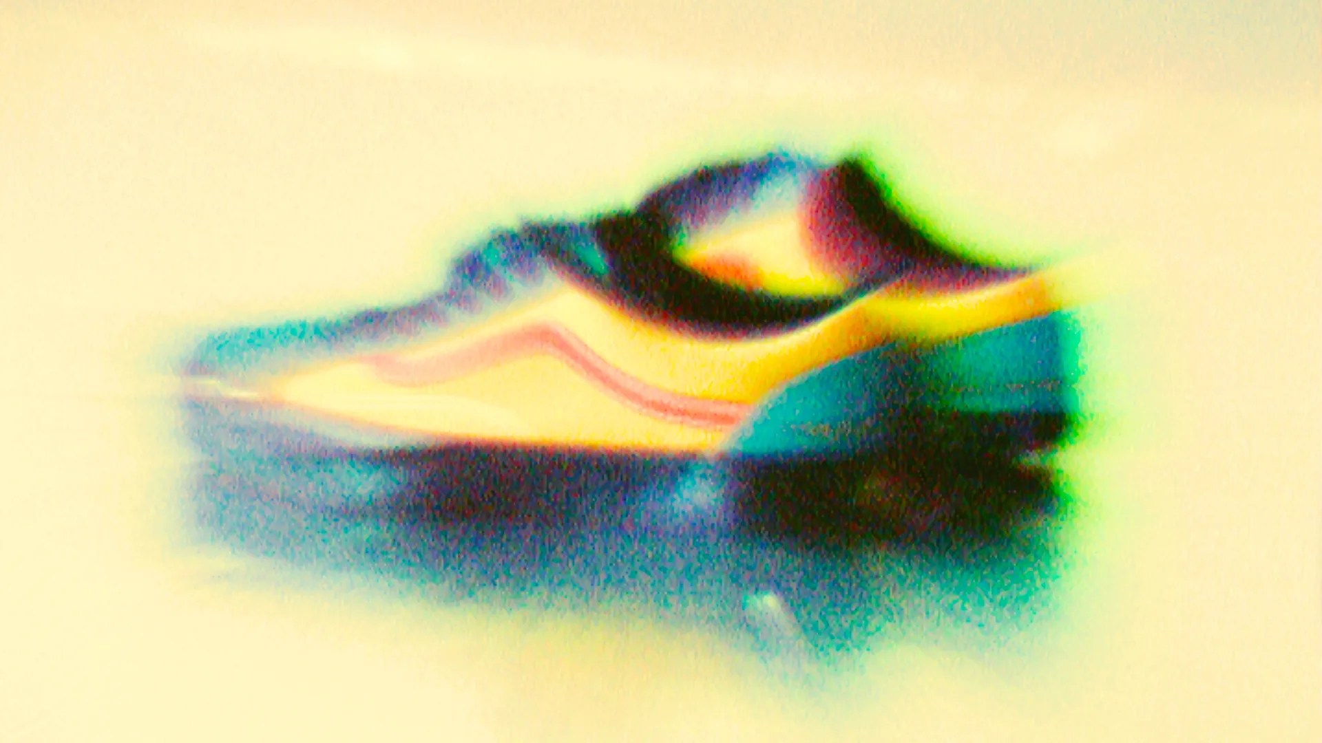 Blurred side view of a sneaker with a yellow upper, red stripe, and dark sole on a light background.