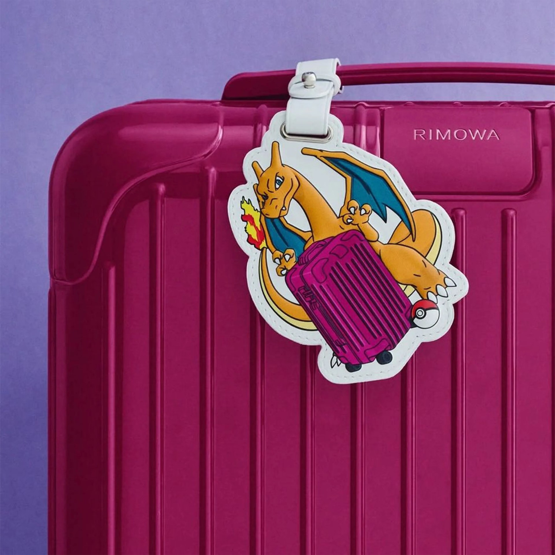 Magenta Rimowa suitcase with a white luggage tag featuring Charizard holding a magenta suitcase and a Pok&eacute; Ball.
