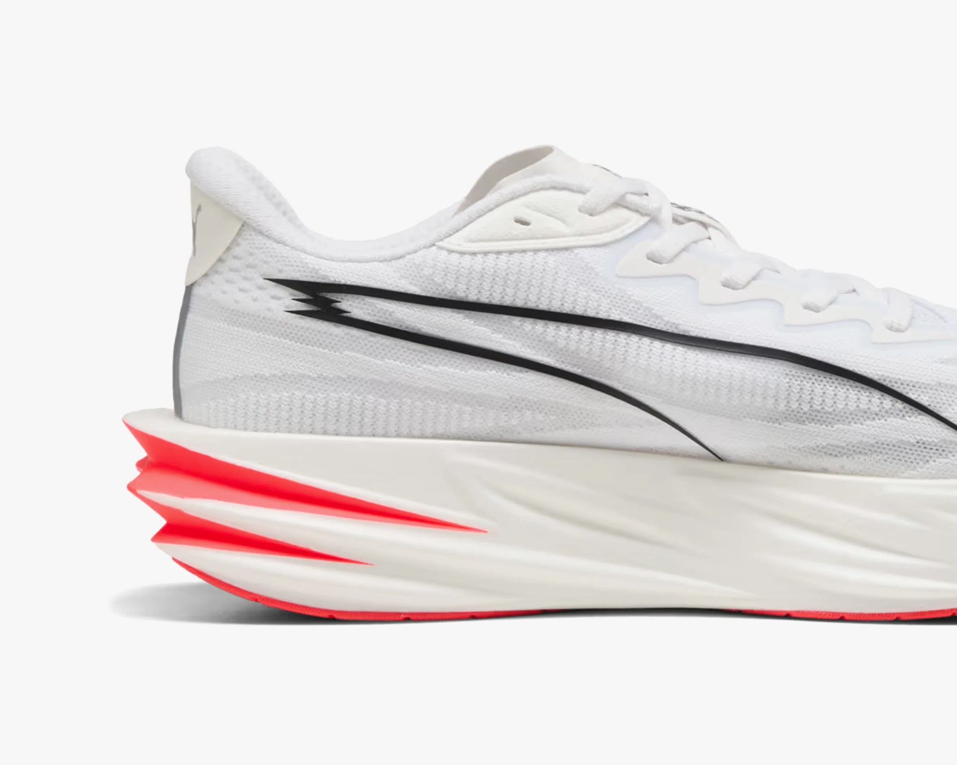 White Nike running shoe with black swoosh and bright red segmented sole.