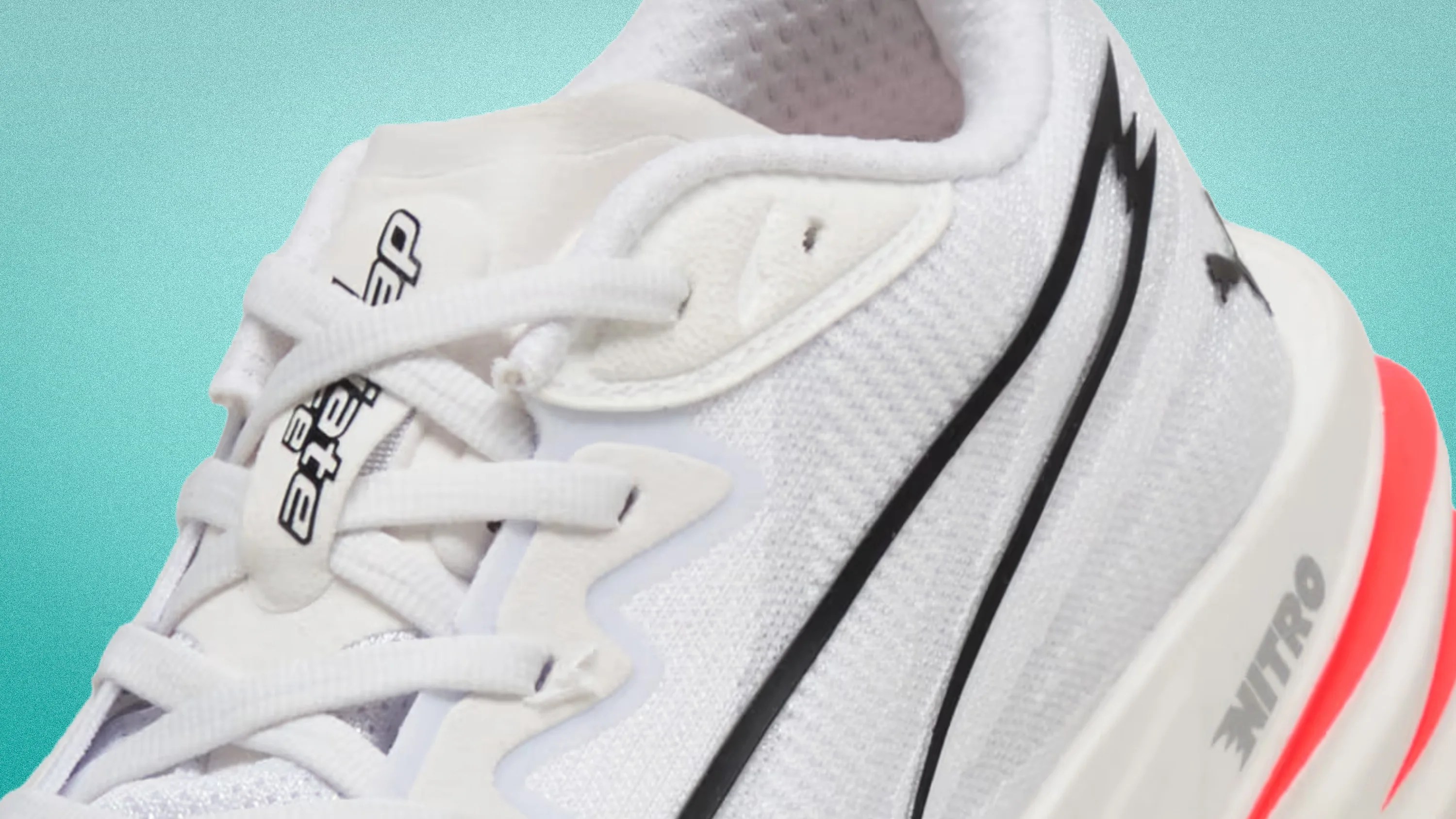Close-up of a white Puma Nitro running shoe with black logo and red accent on the sole.