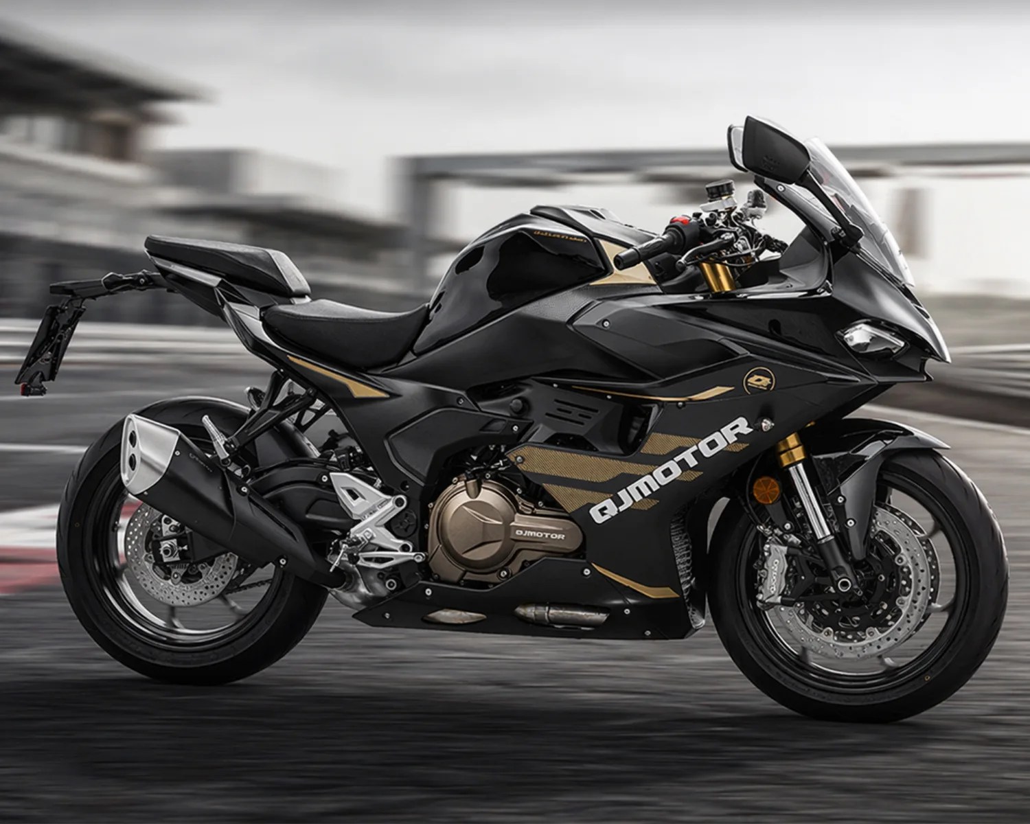 Black and gold QJMotor sport motorcycle with full fairing on a racetrack.