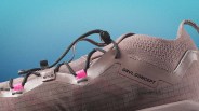 Close-up of a mauve GRVL CONCEPT sneaker with black laces and pink lace loops against a blue gradient background.