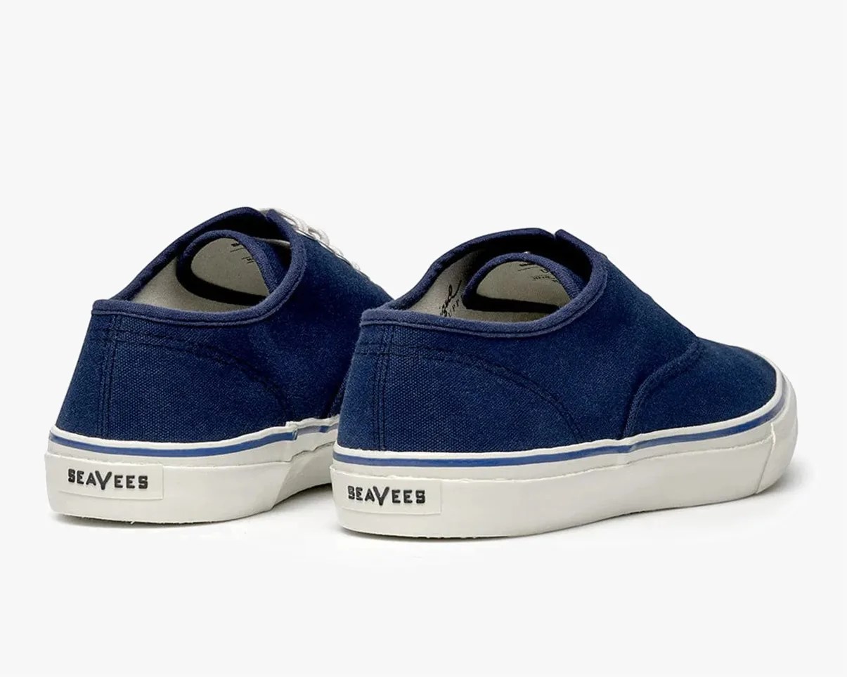 Pair of navy blue canvas sneakers with white rubber soles and "SeaVees" logo on the heel.