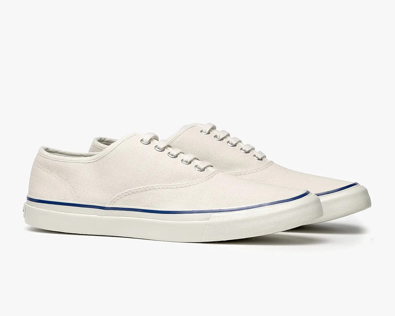 Pair of off-white canvas low-top sneakers with white rubber soles and a thin blue stripe above the sole.