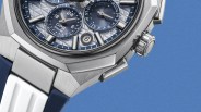 Close-up of a silver metal watch case with blue and white textured dial and a blue and white rubber strap.