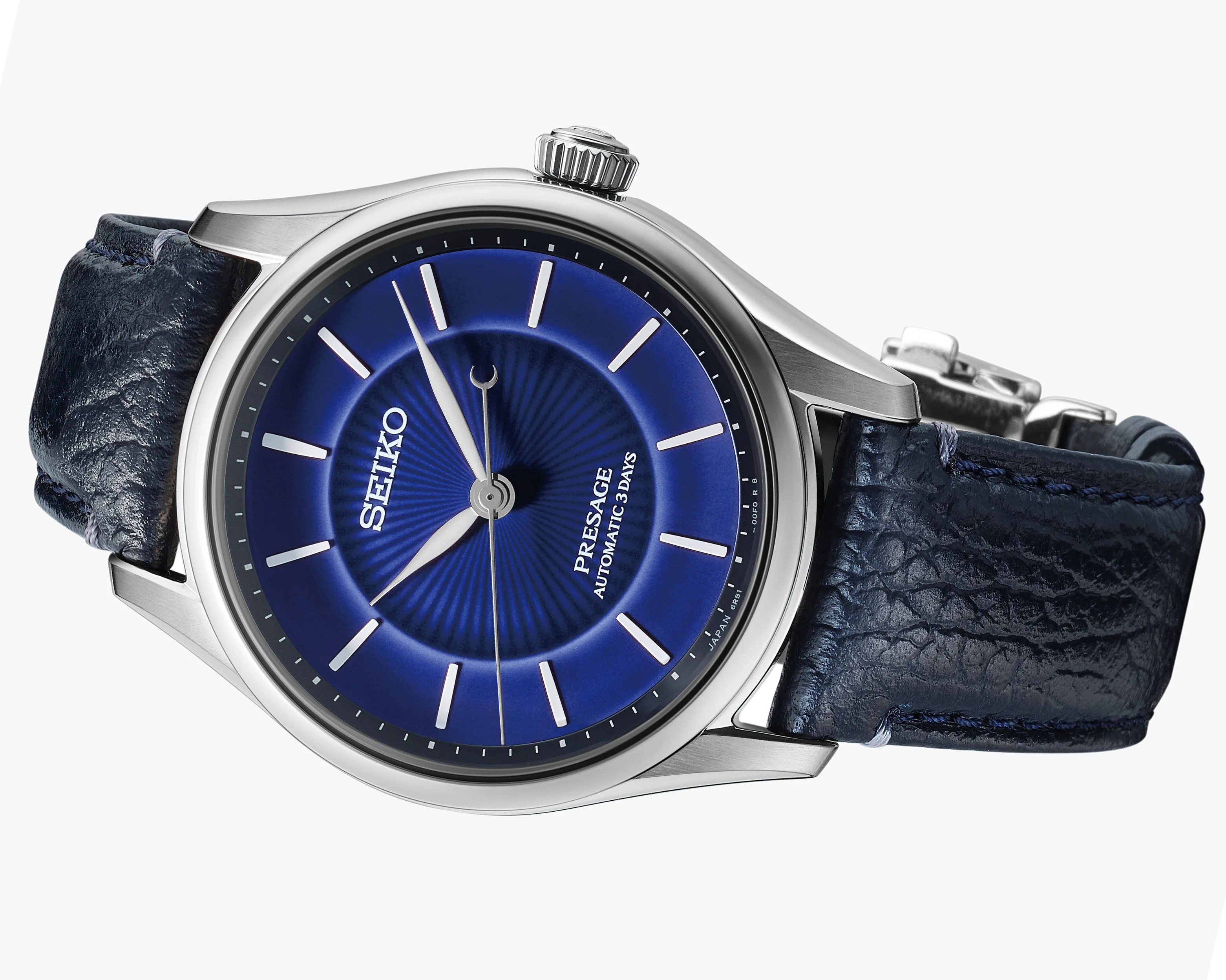 Close-up of a Seiko Presage watch with a blue sunburst dial, silver markers, and a textured dark blue leather strap.