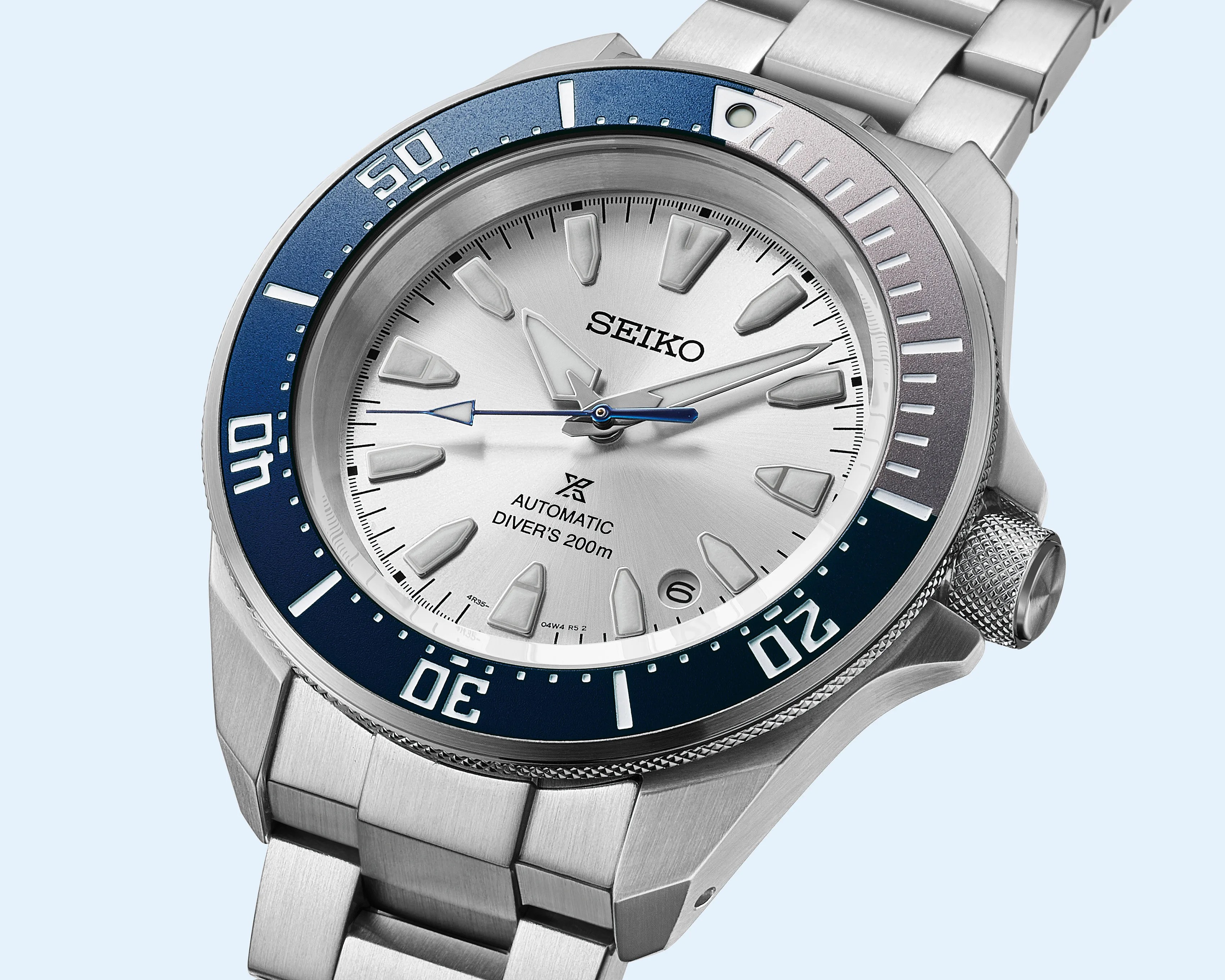 Silver Seiko automatic diver's watch with blue and silver bezel and stainless steel bracelet.
