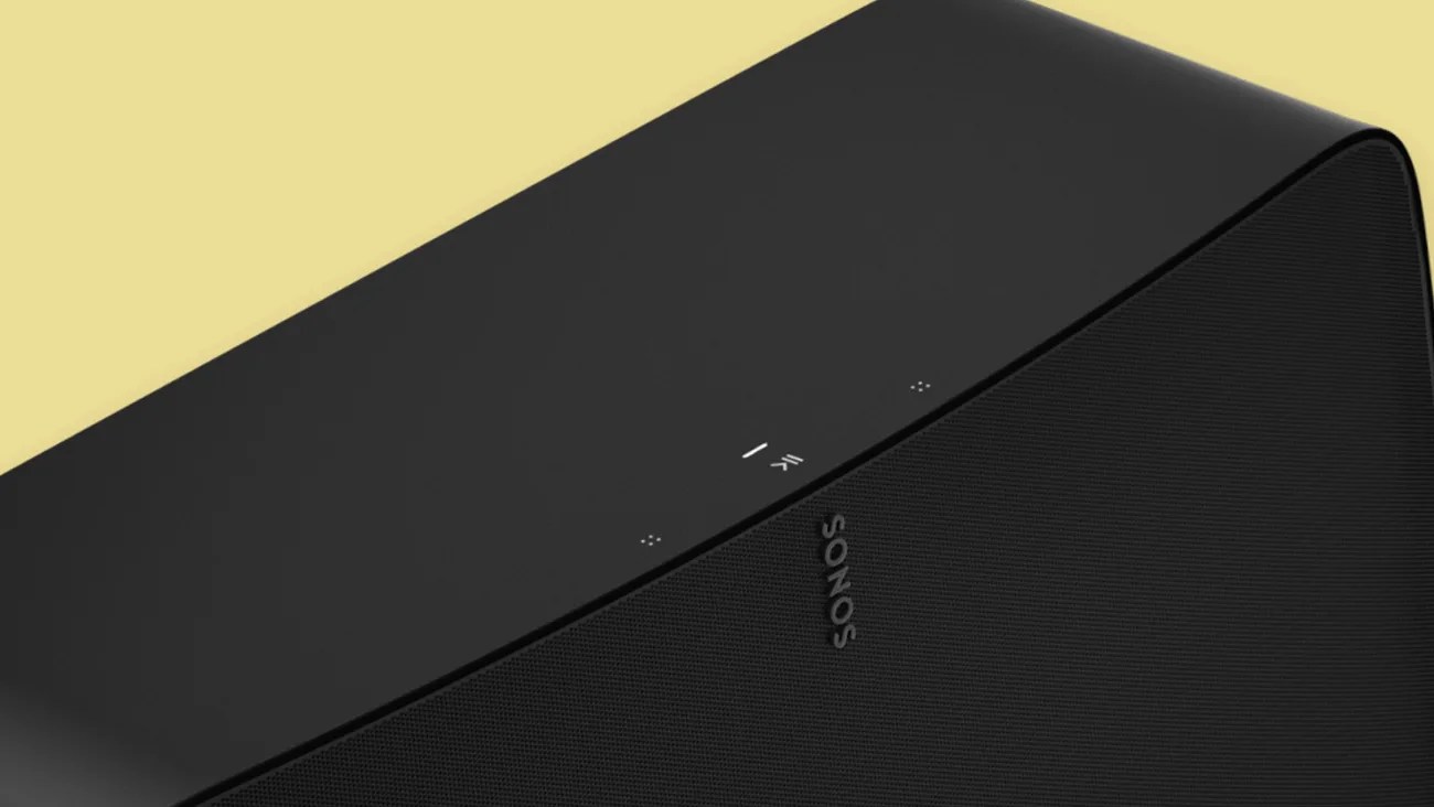 Black Sonos wireless speaker with touch controls on top against a yellow background.