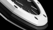 Close-up of a white and black octagonal watch bezel with hexagonal screws and textured surface.