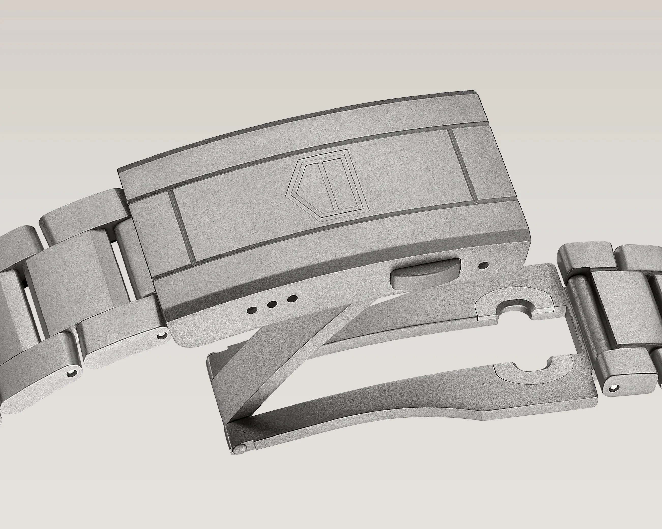 Matte gray metal watch clasp with engraved geometric logo and linked bracelet segments.