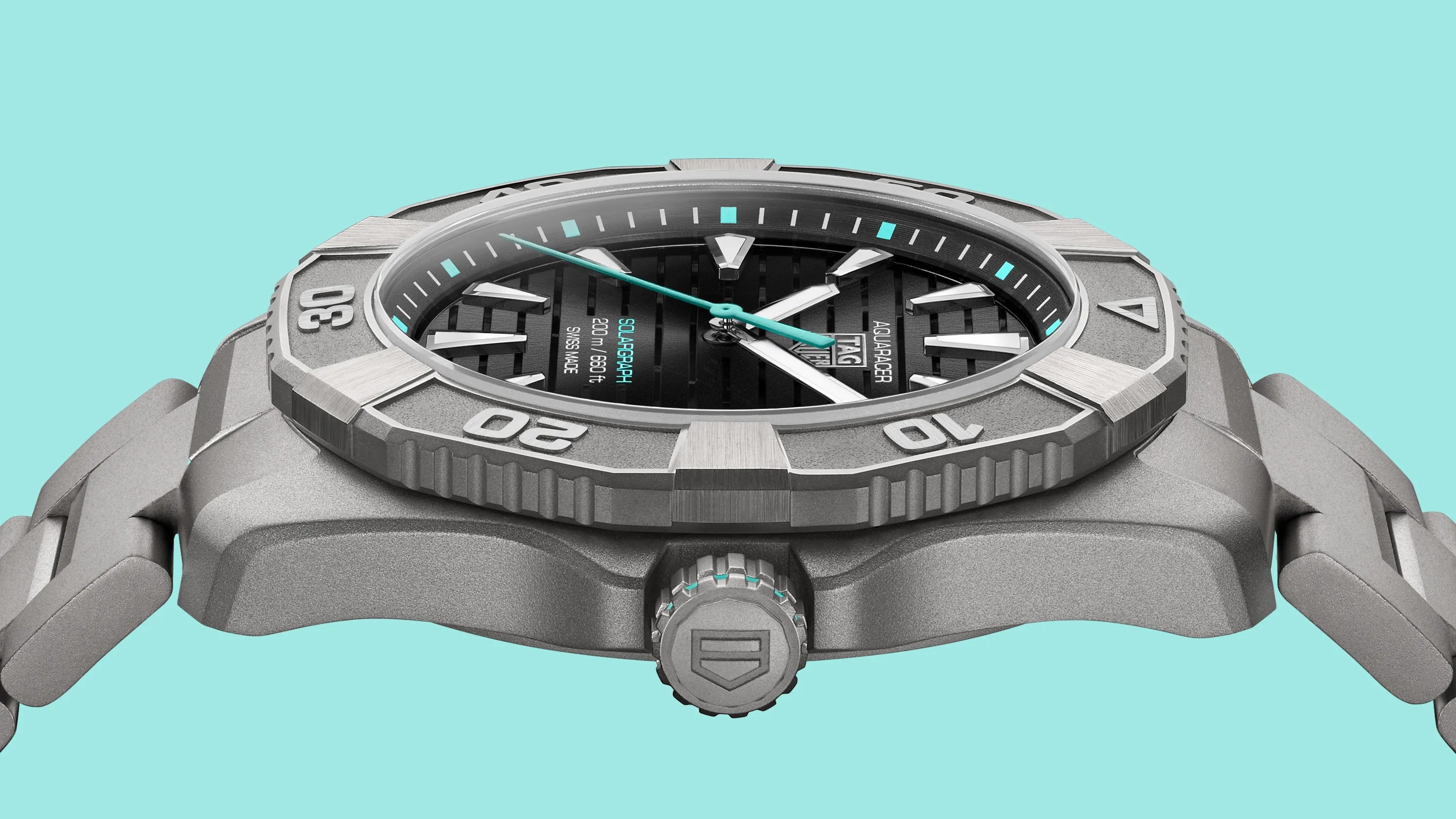 Close-up of a TAG Heuer Aquaracer Solargraph watch with a black dial, silver markers, and a gray metal case and bracelet.