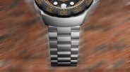 Matte silver metal watch band with wide links attached to a black bezel watch face.