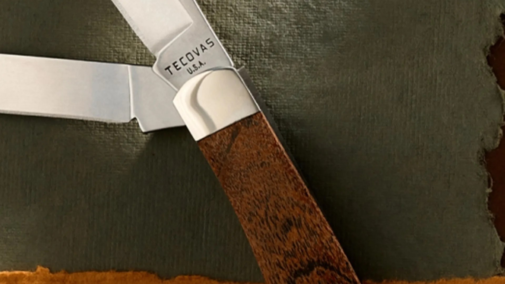 Folding pocket knife with wooden handle and "TECOVAS U.S.A." engraved on the blade.