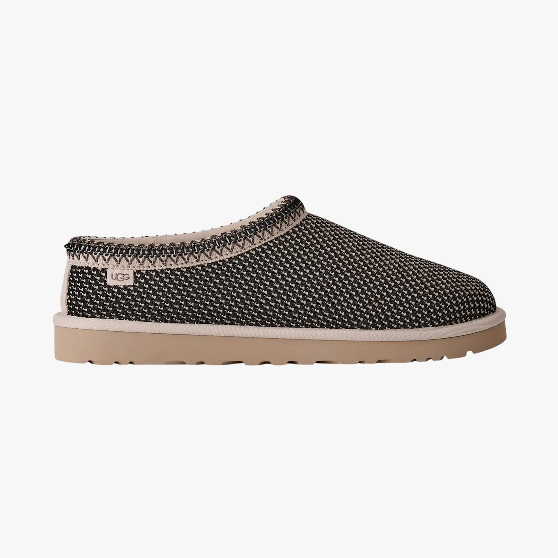 Black and white woven UGG slip-on shoe with beige sole and stitched trim.