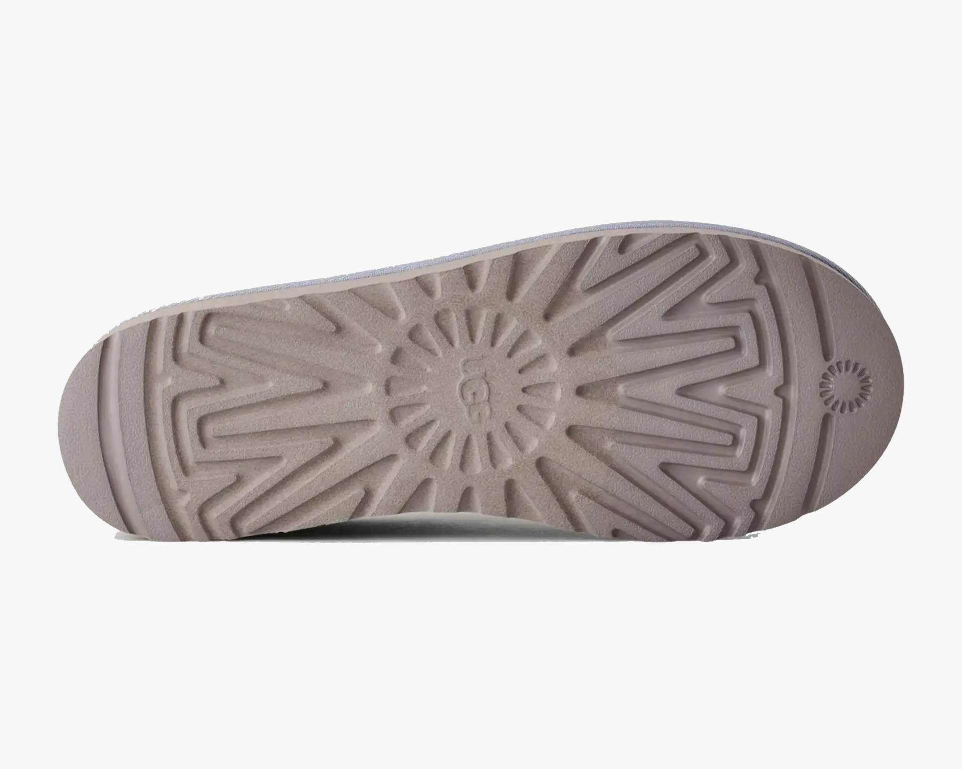 Beige rubber sole of a shoe with a sunburst pattern and the UGG logo in the center.