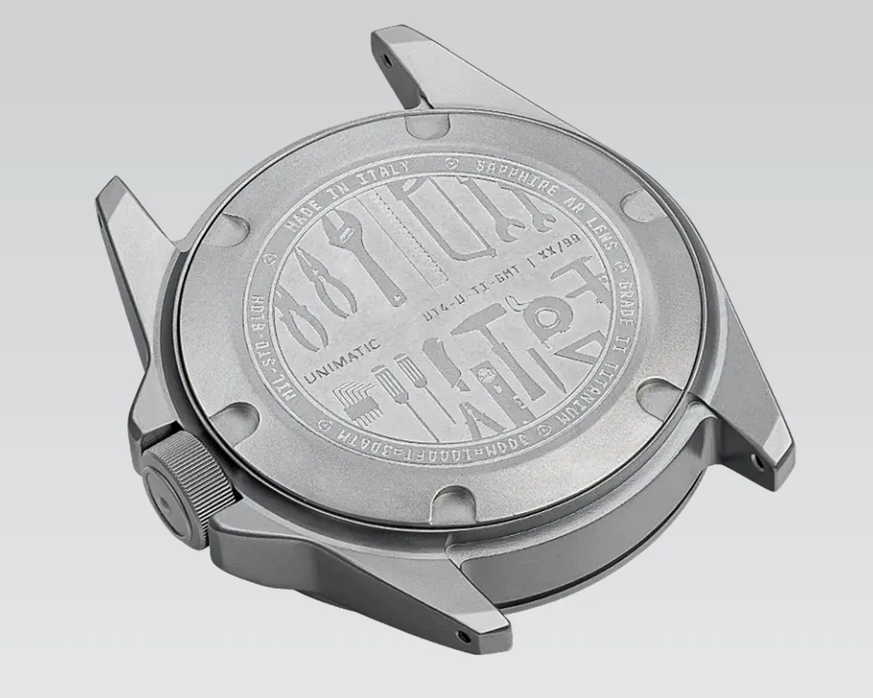 Silver stainless steel watch case back with engraved tools and text, including "Made in Italy" and "Unimatic.