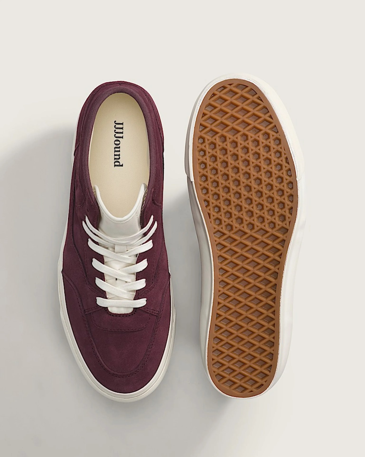 Pair of maroon suede sneakers with white laces and gum rubber soles, one showing top view and the other sole.