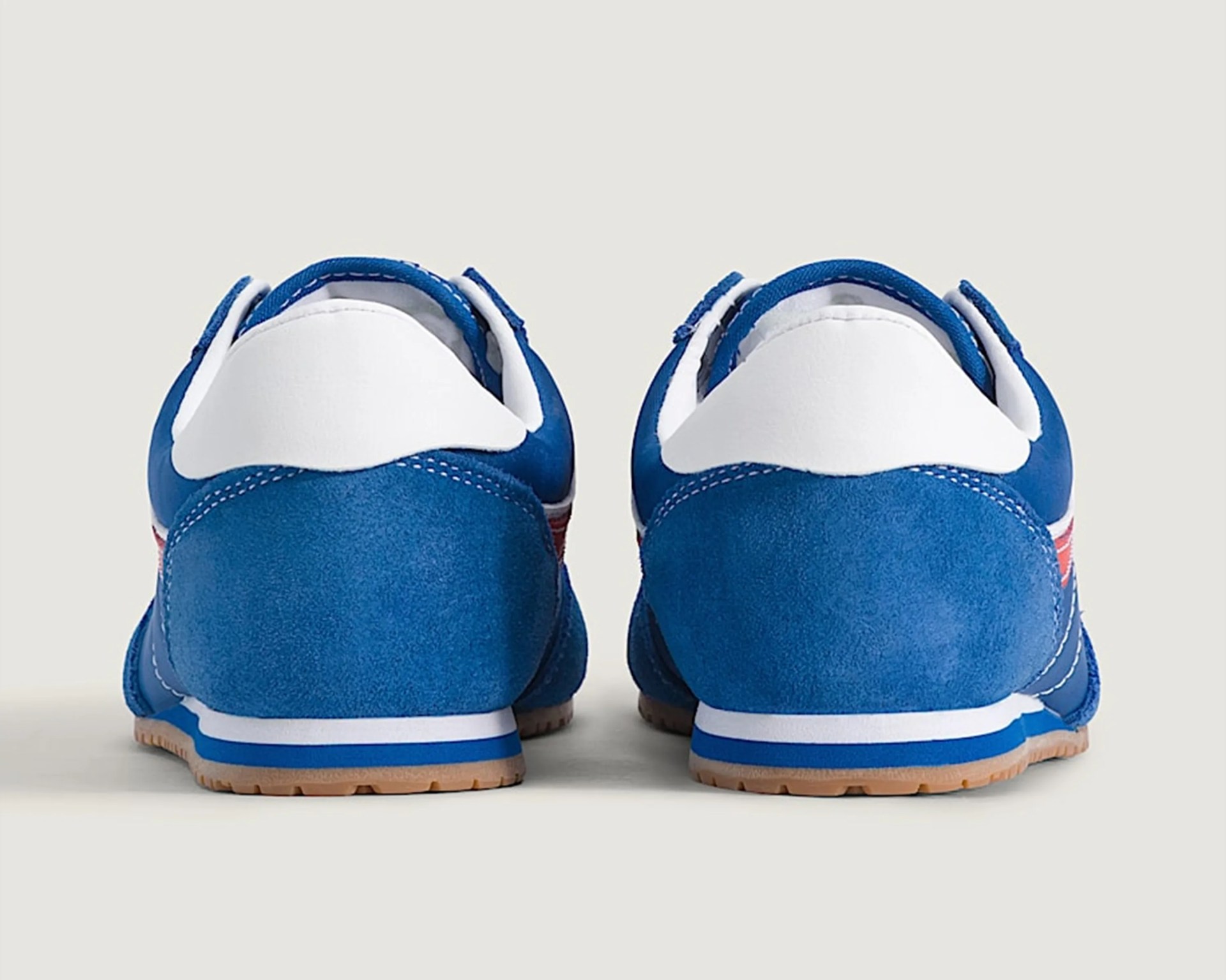 Pair of blue and white sneakers shown from the back with gum soles and blue and white midsoles.