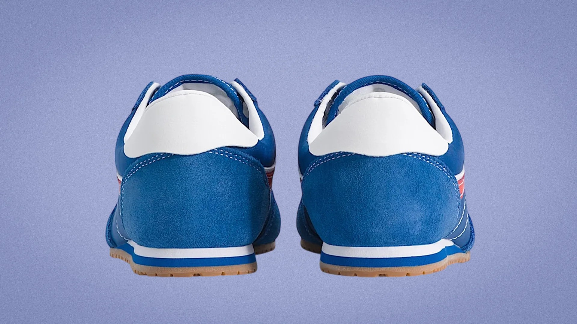Pair of blue and white sneakers with gum soles shown from the back on a purple background.