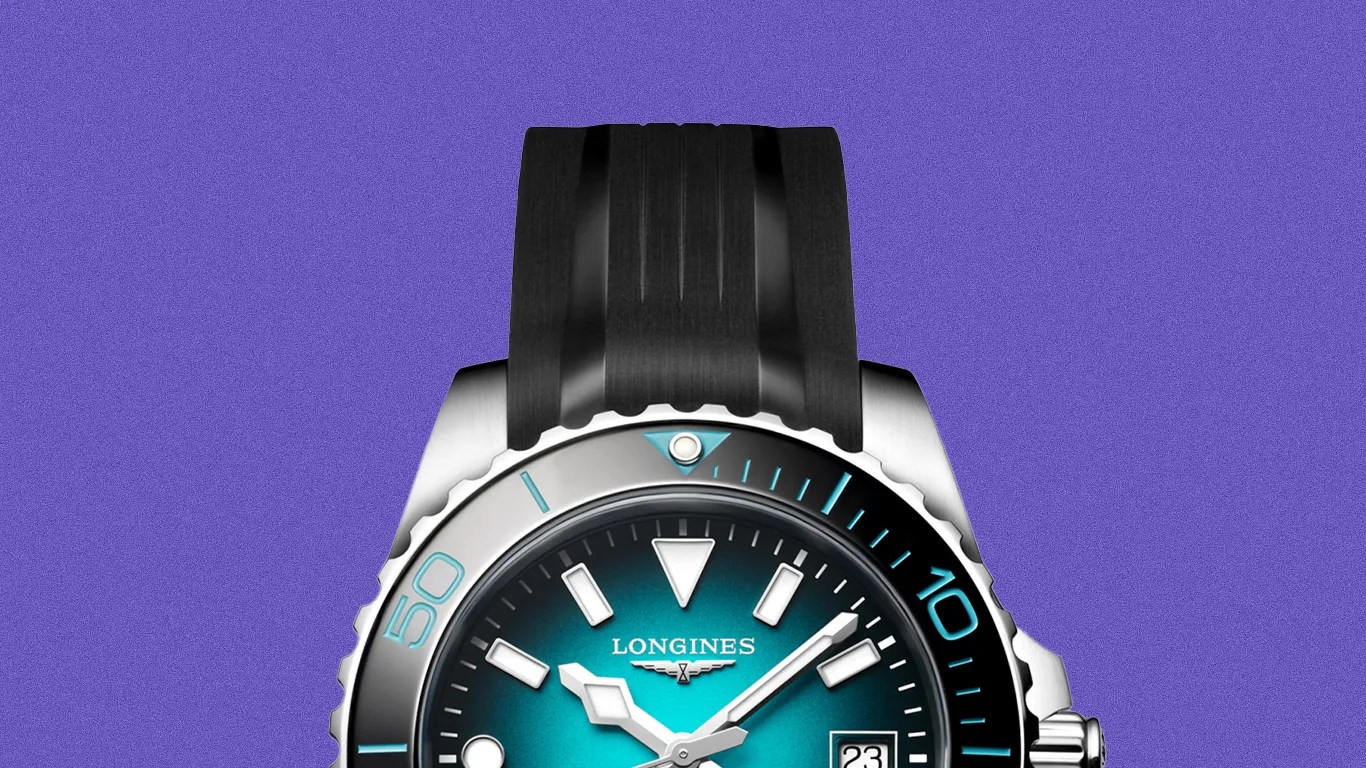 Longines watch with a gradient blue dial, silver markers, black rubber strap, and silver bezel with blue accents.