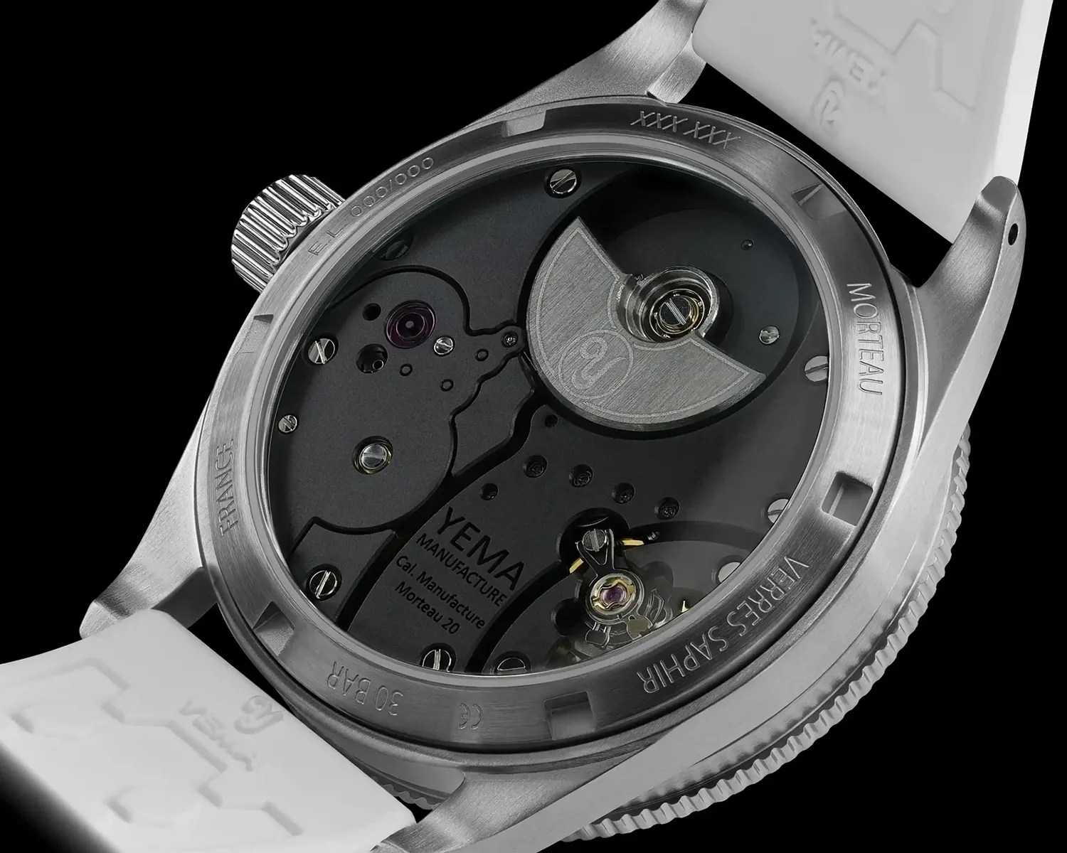 Close-up of the back of a Yema watch showing the automatic movement with "YEMA Manufacture Cal. Manufacture Morteau 20" engraved on the mechanism.