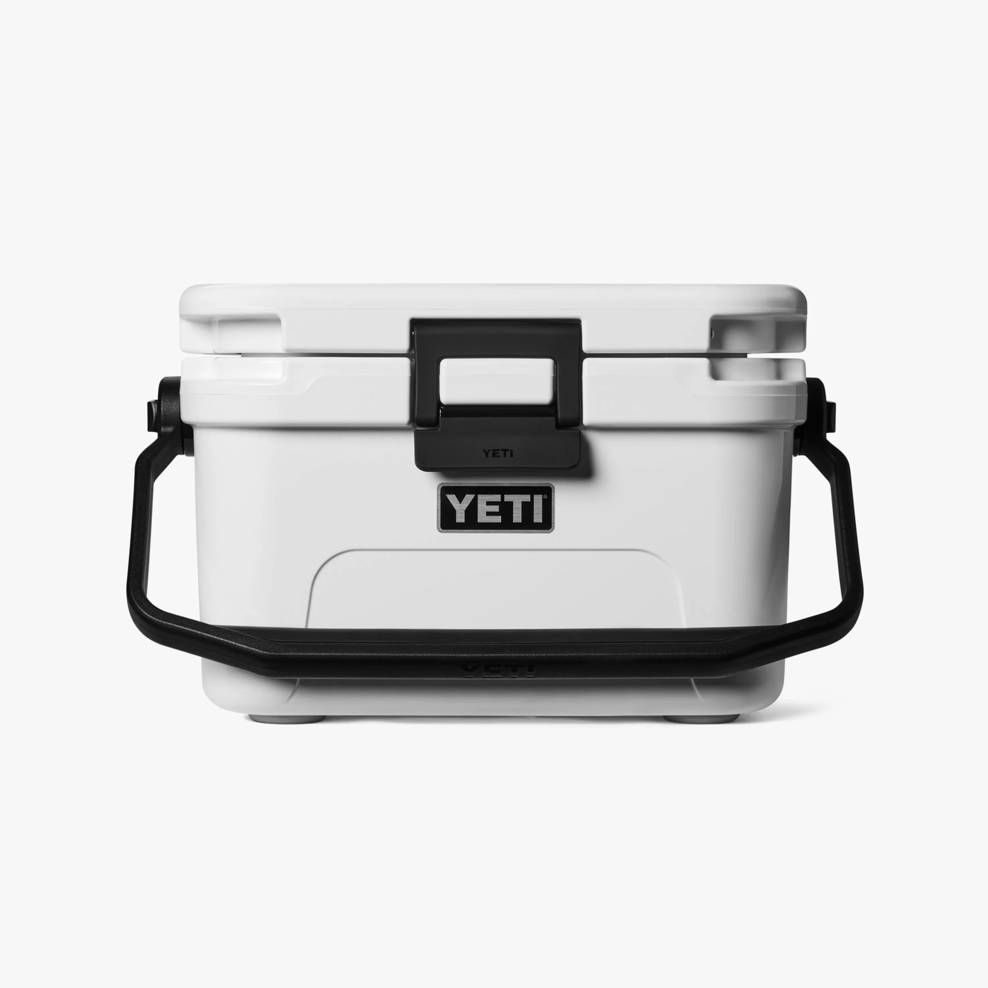 White YETI cooler with black latch and black handle on a white background.