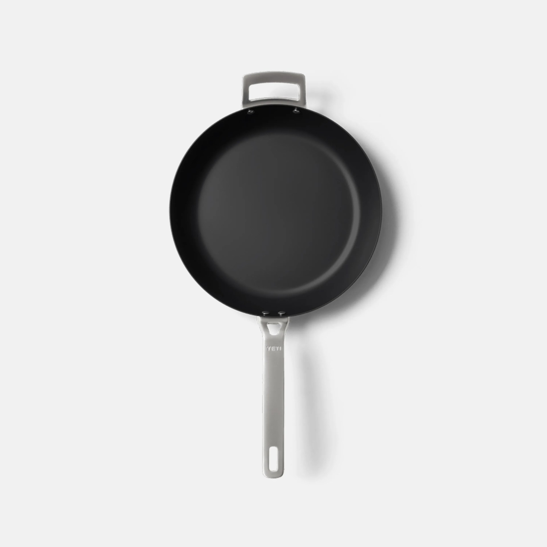 Black nonstick frying pan with a white handle and helper handle on a white background.