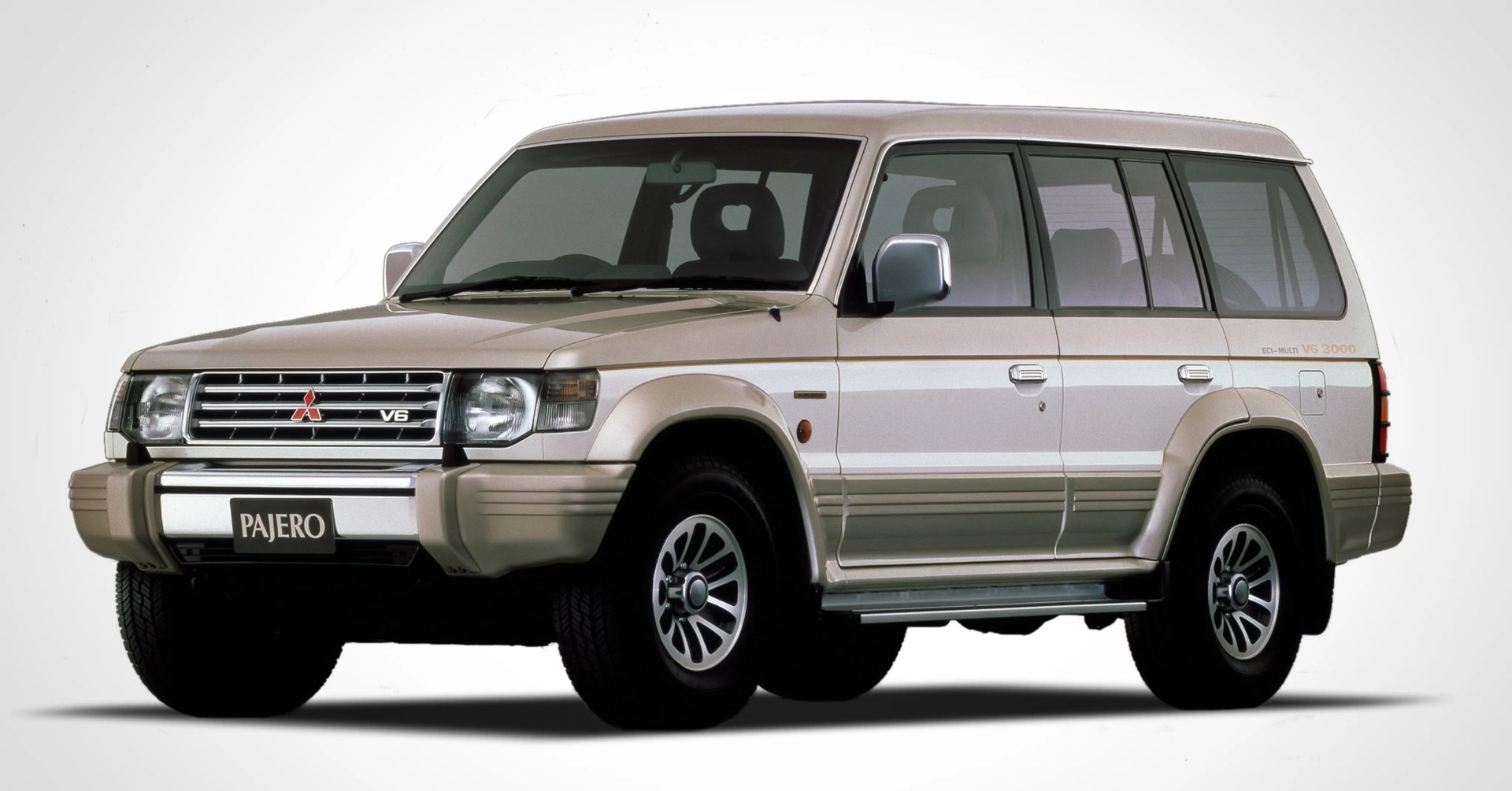 Beige Mitsubishi Pajero V6 3000 SUV with tinted windows and alloy wheels on a white background.