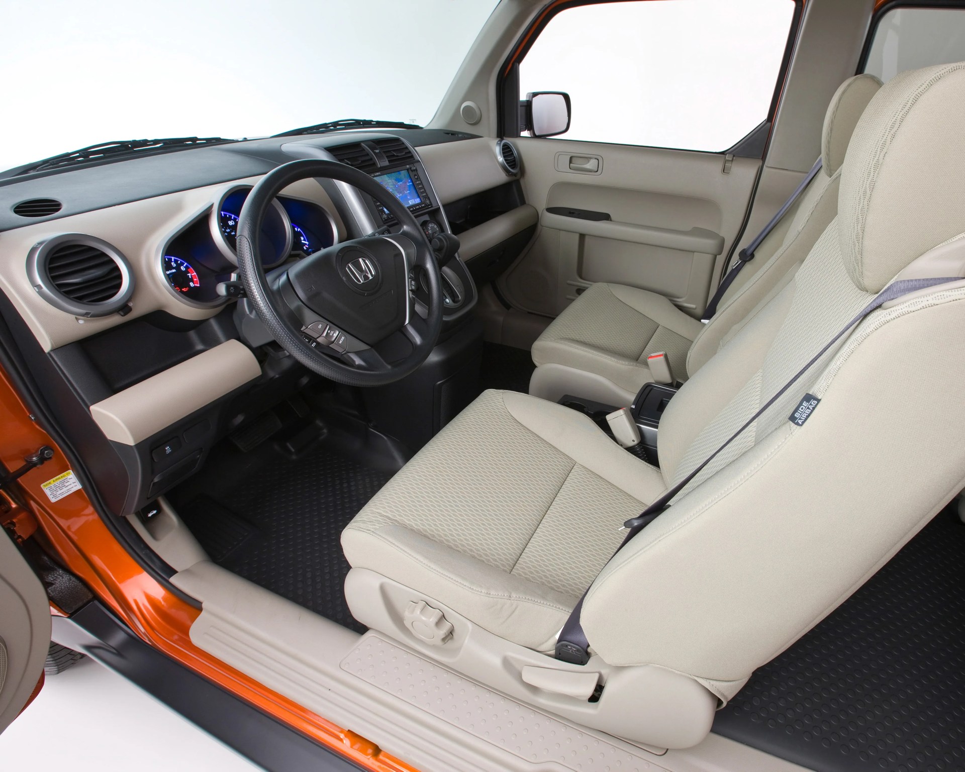 Beige fabric front seats and black steering wheel inside an orange Honda car interior.