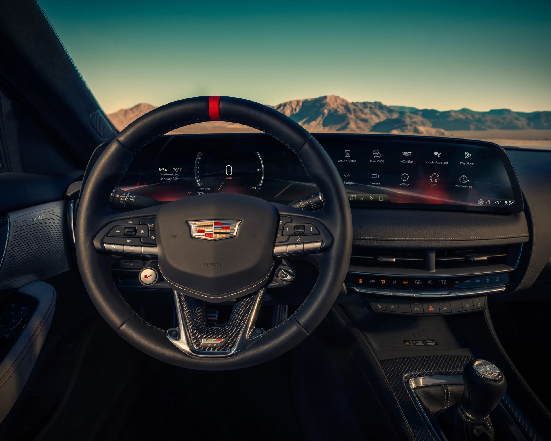 Black leather Cadillac steering wheel with red center stripe and digital dashboard display showing vehicle status and settings.