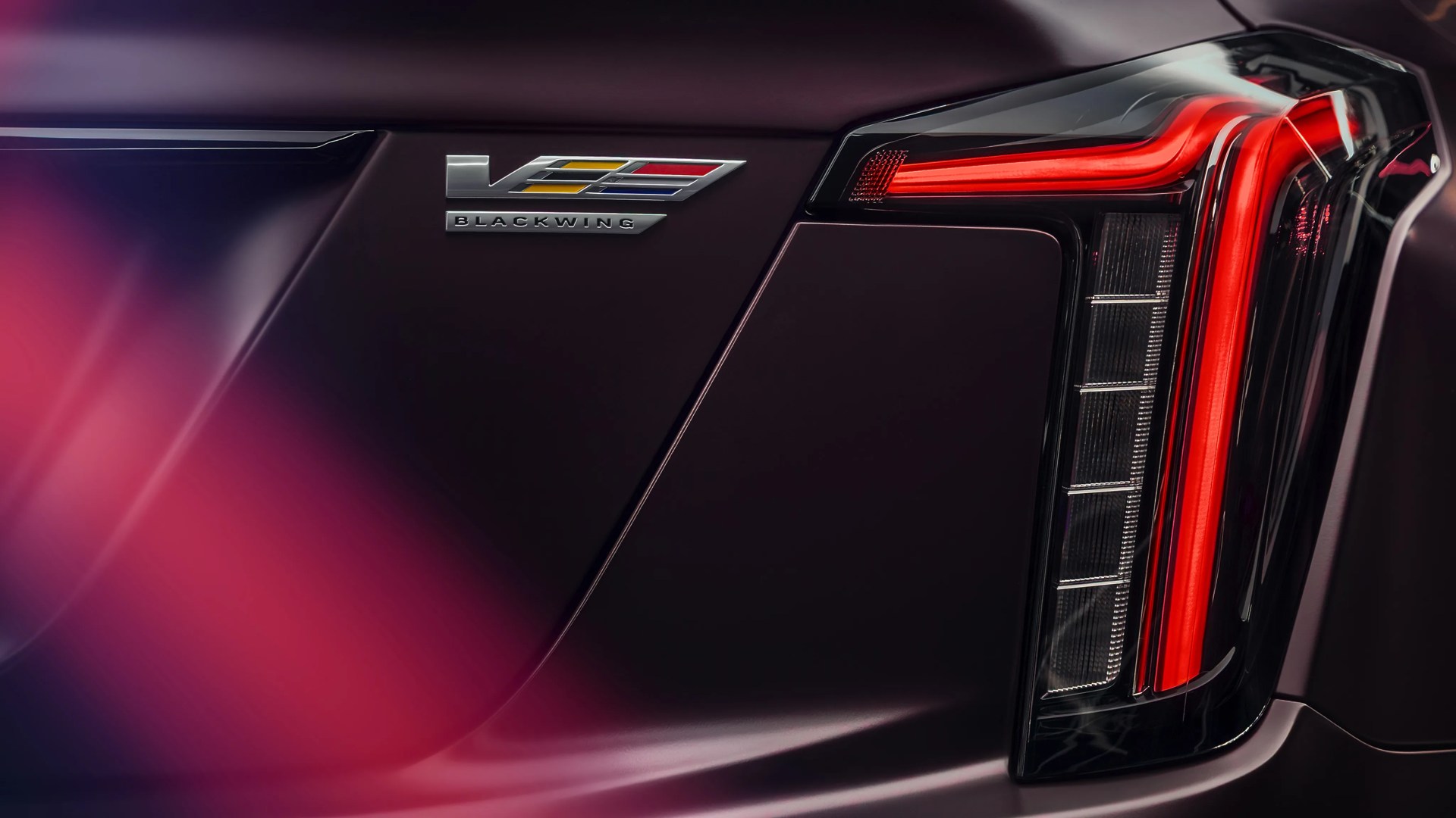 Close-up of a dark purple car rear with a V Blackwing badge and a vertical red LED taillight.