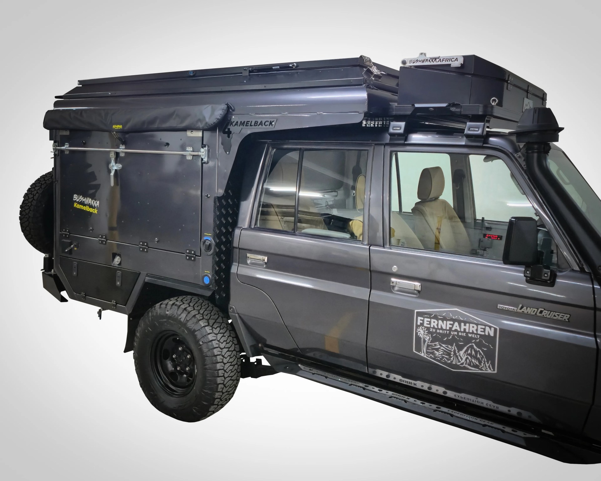 Black Toyota Land Cruiser with off-road modifications including roof storage box, snorkel, and rear storage compartment.