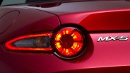 Close-up of a red Mazda MX-5 rear taillight with illuminated circular brake light.