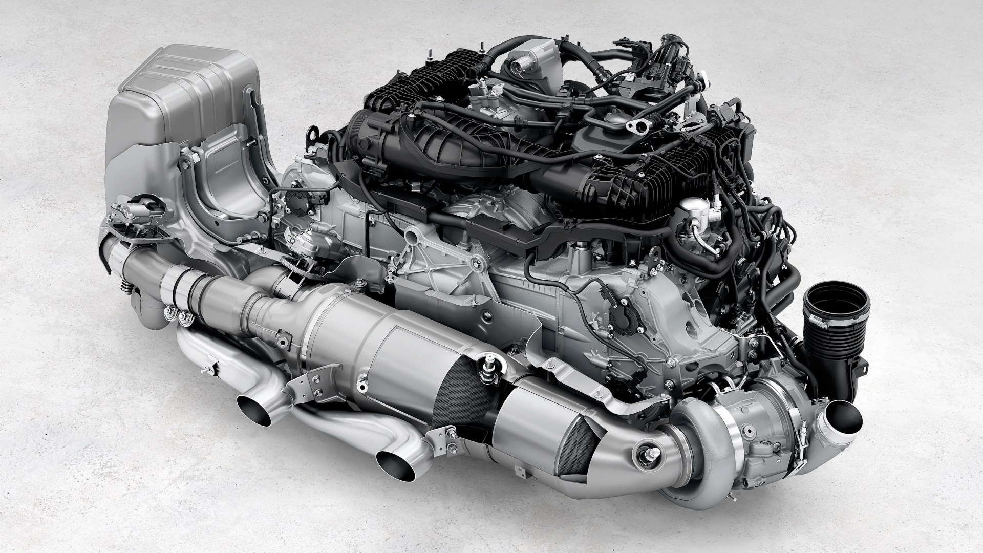 High-performance automotive engine with turbocharger and exhaust system on a light gray surface.
