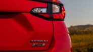 Rear section of a red Subaru Impreza RS with visible taillight and badges.