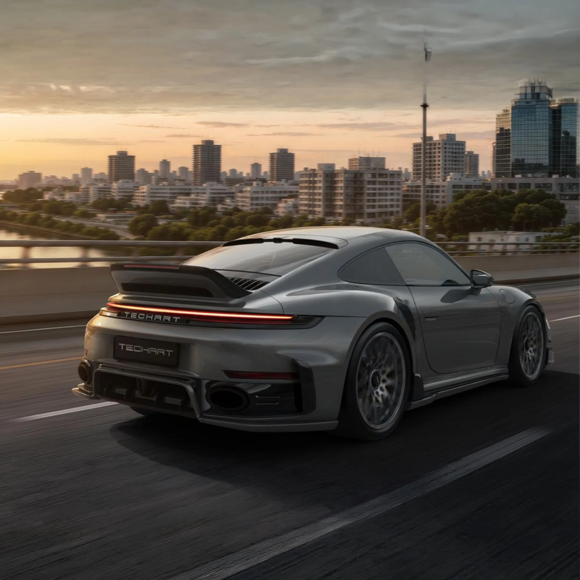 Gray TechArt sports car rear view on a city road at sunset with buildings in the background.