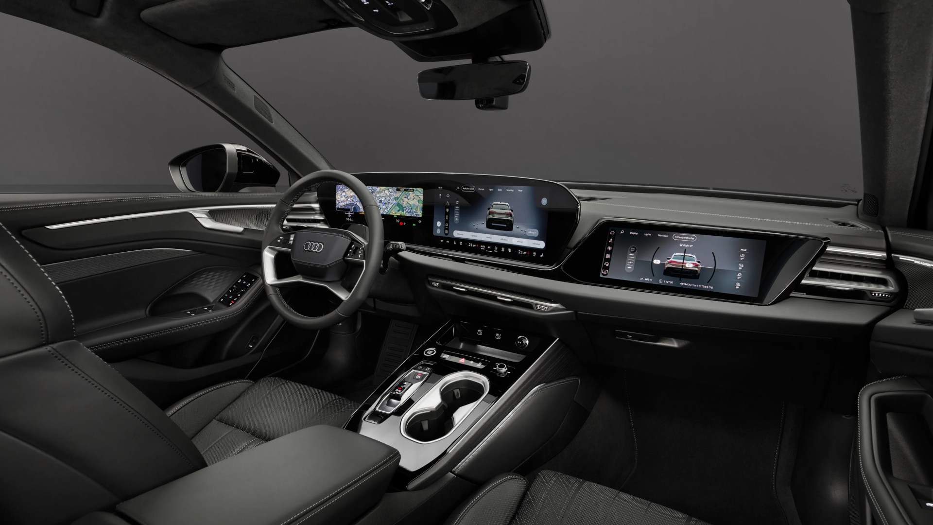 Black leather Audi car interior with digital dashboard, dual touchscreen displays, and center console cup holders.