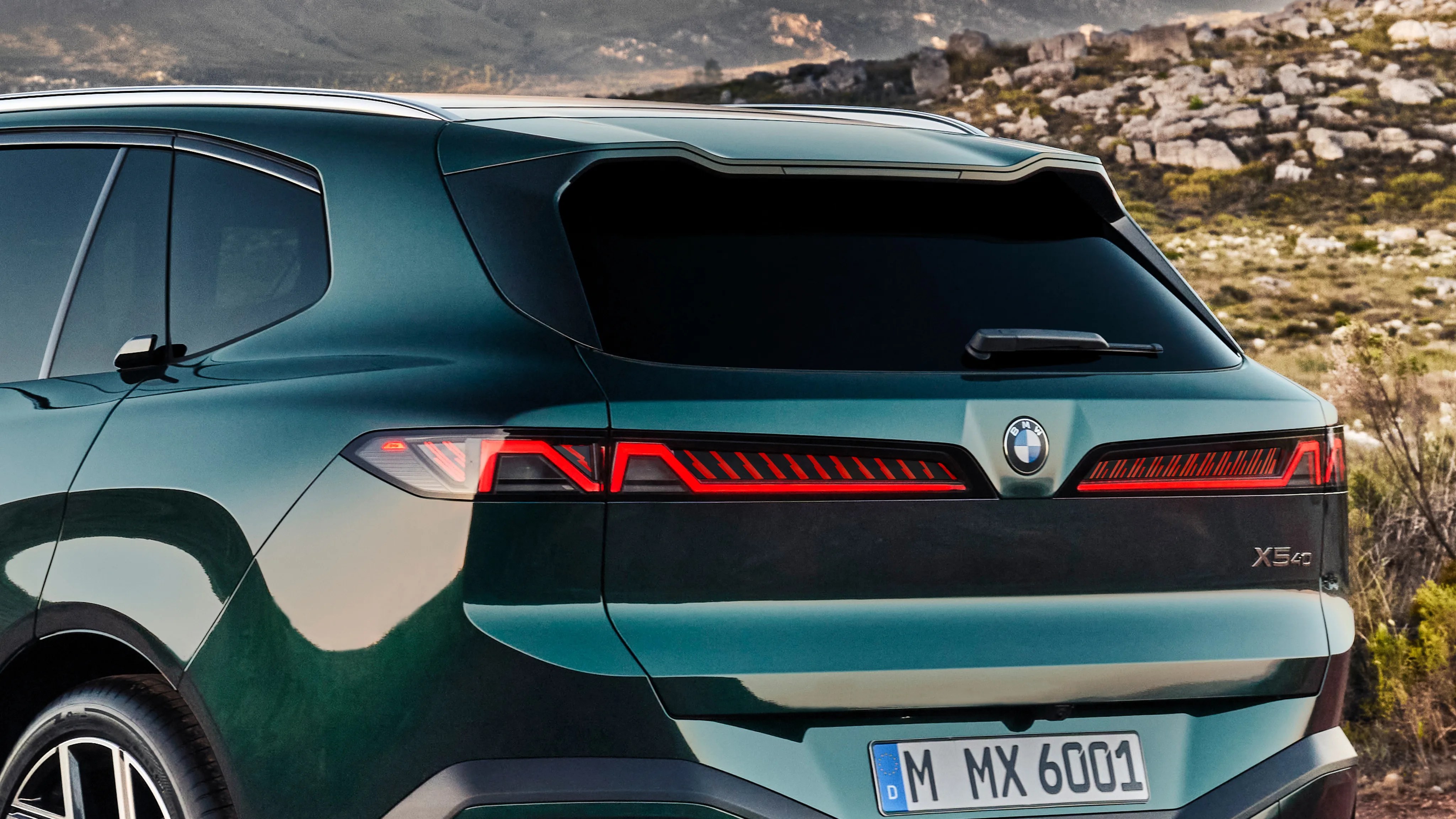 Rear side of a green BMW X5 40 with distinctive LED taillights and tinted rear window in an outdoor setting.