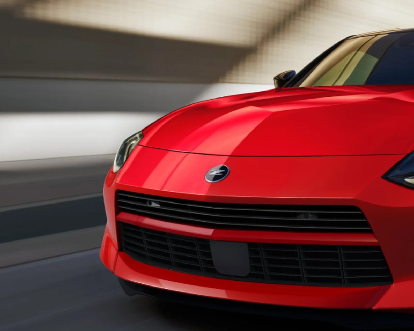 Front view of a red sports car with sleek headlights and a black grille.