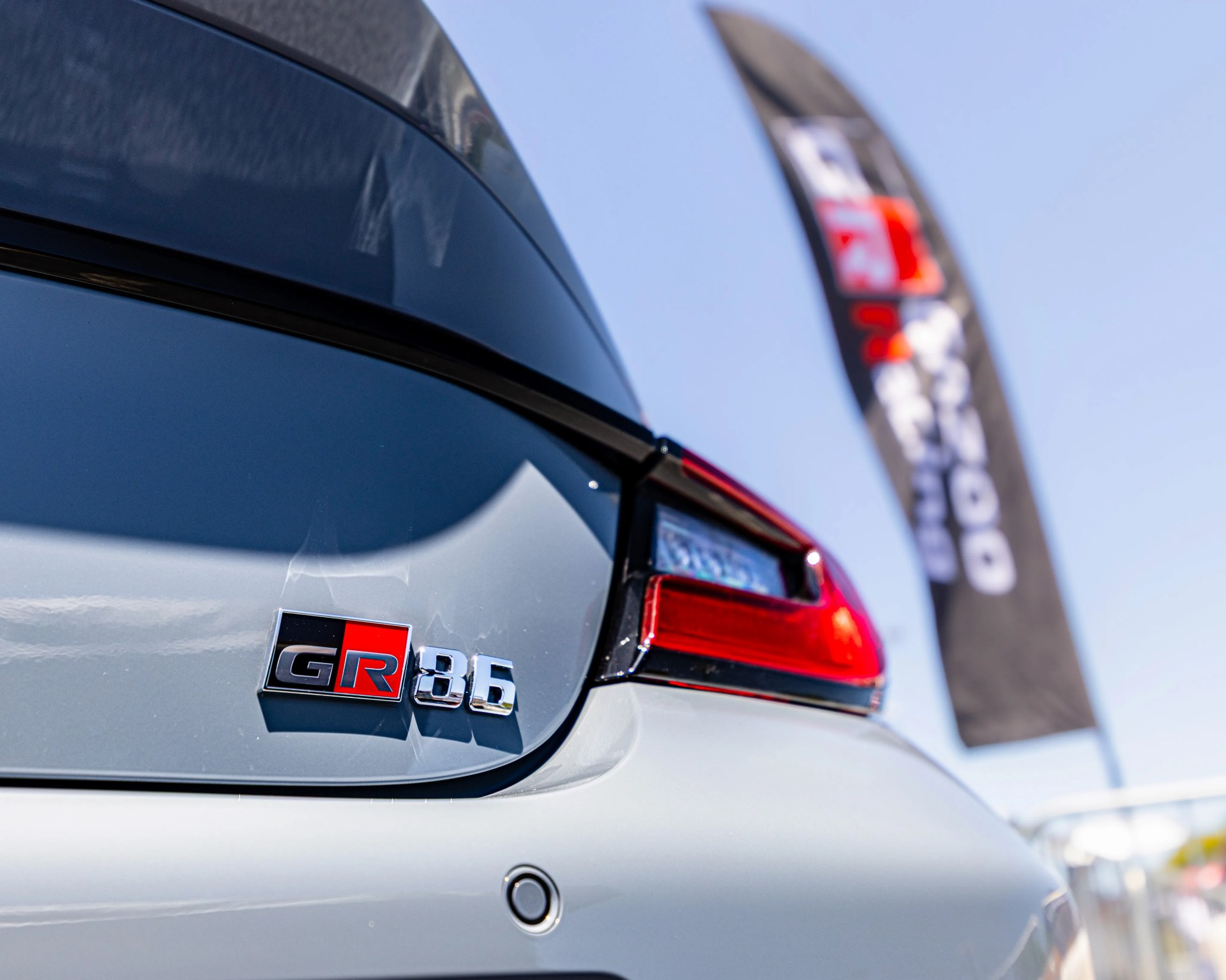 Close-up of a silver Toyota GR 86 rear with taillight and black rear window trim.