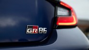 Close-up of a blue car's rear with a "GR 86" badge and a partially visible red taillight.