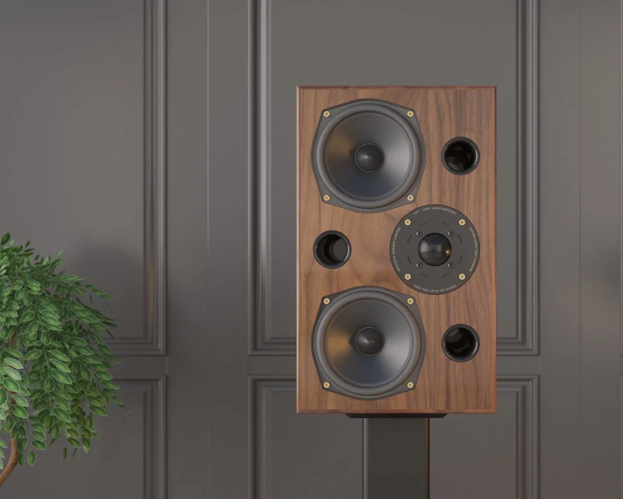 Wood-finished speaker with two large black drivers, a central tweeter, and three circular ports on a stand against a gray paneled wall.