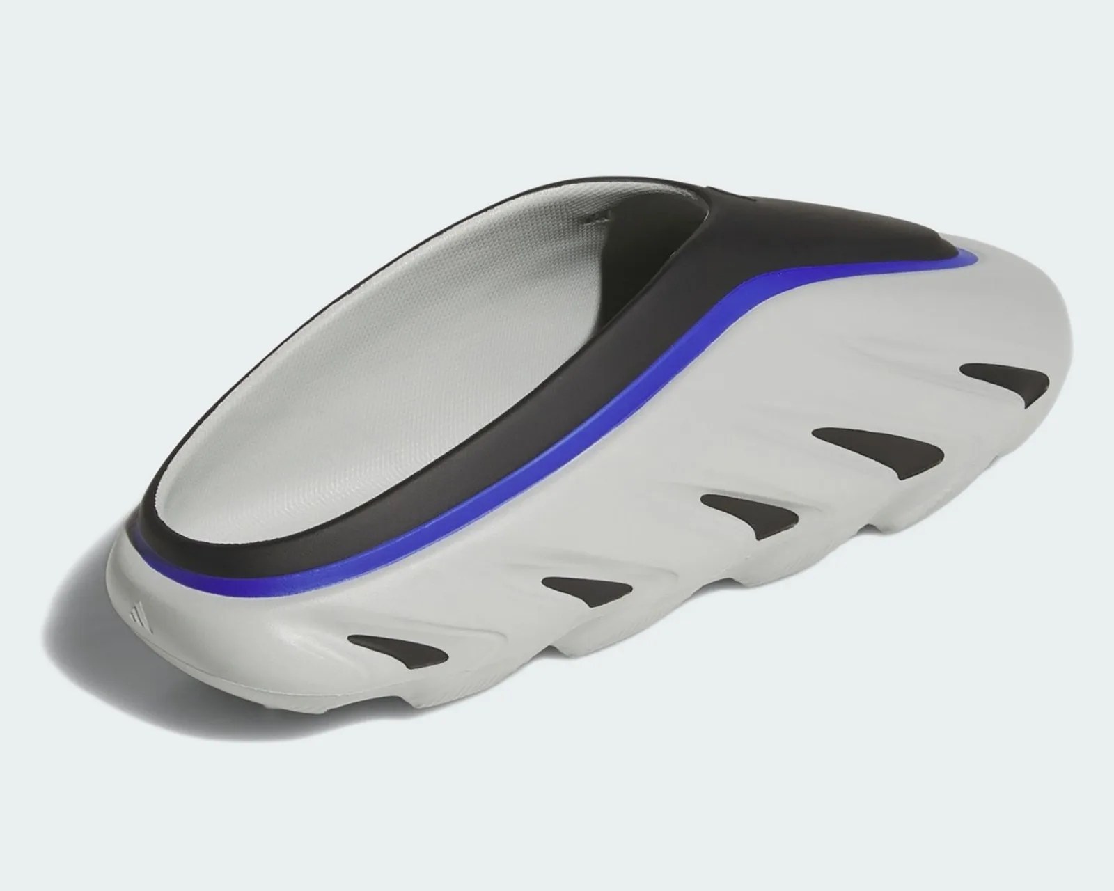 White and black slip-on shoe with blue trim and cutout details on the sole.